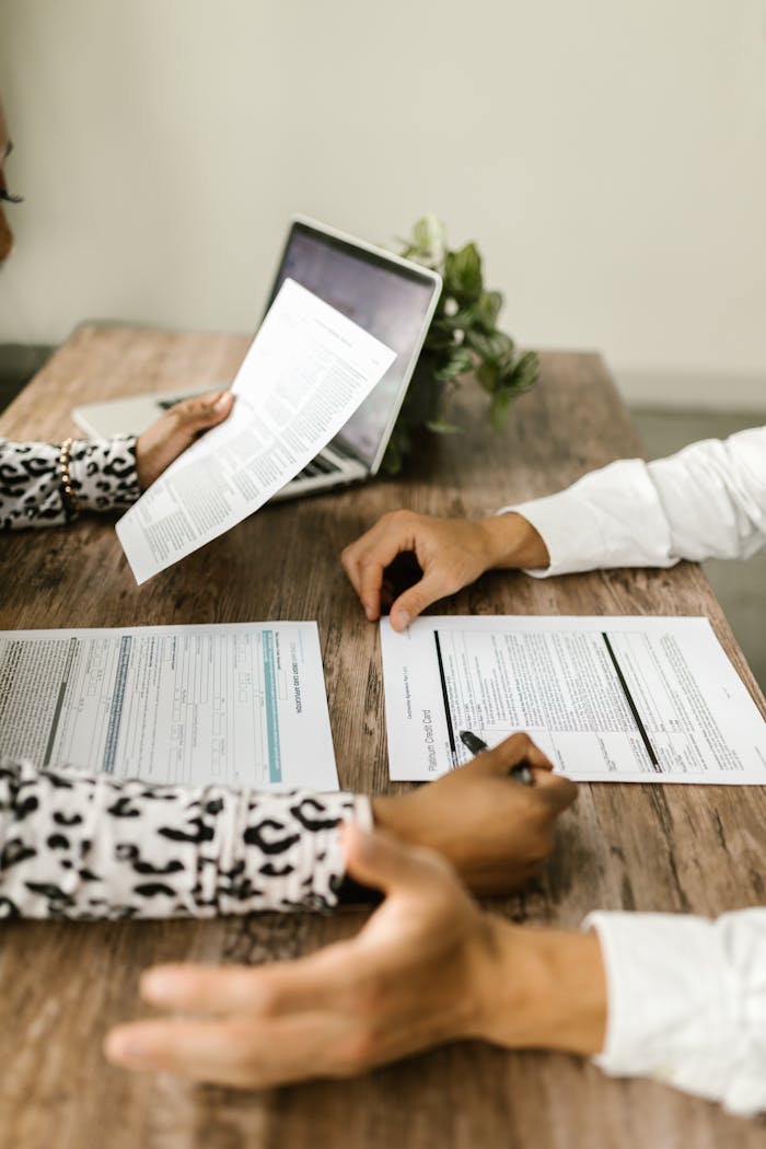 gallery-05 Two people reviewing documents at a wooden table during a business meeting.